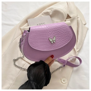 Detail view of lavender faux crocodile saddle bag with butterfly buckle and silver chain