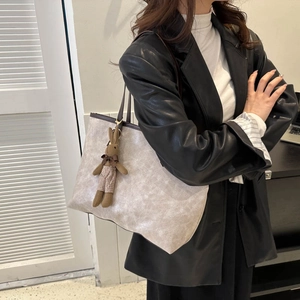 Large capacity off-white tote bag with textured finish and brown leather handles