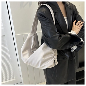 Détail du grand sac bandoulière en nylon crème avec texture plissée et fermeture éclair