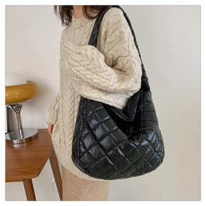 Detailed quilted texture of a black large capacity tote bag with soft padding