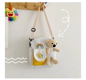 Détail du sac bandoulière mignon en toile avec patch arc-en-ciel et poche avant jaune