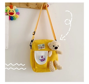 Détail du sac bandoulière en toile jaune avec broderie cupcake et peluche ours mignonne