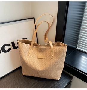 Detail of khaki woven faux leather tote bag showing intricate texture and fashion label