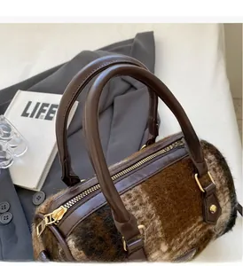 Detail der zylindrischen Boston Bag mit braunem Plaid-Plüschstoff und Ledergriffen
