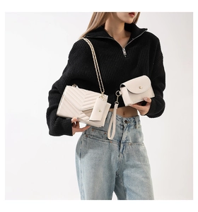 Dettaglio borsa a tracolla trapuntata crema con catena dorata e set di mini pochette