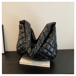 Close-up of black quilted hobo bag with large diamond stitching and soft nylon texture