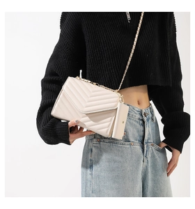 Dettaglio borsa a tracolla trapuntata a V beige con catena e mini pochette rimovibile