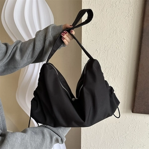 Grand sac à bandoulière en nylon noir de forme demi-lune avec un design souple minimaliste