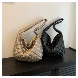 Quilted crossbody bags in metallic gold and black displayed on a wooden surface