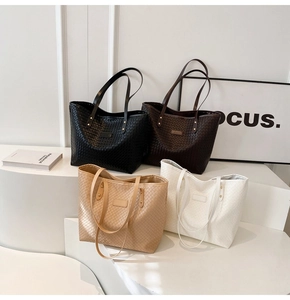 Macro shot of large woven tote bags in four colors on a white geometric display