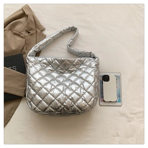 Overhead view of silver quilted tote bag with metallic finish and wide shoulder strap