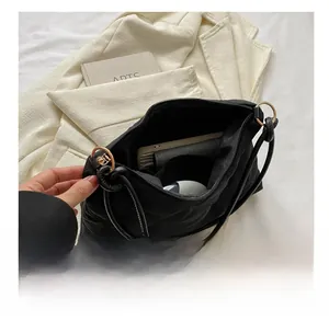 Spacious interior of black quilted nylon shoulder bag showing daily essentials storage