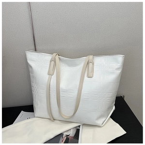 Detailed close-up of the vintage white tote bag featuring a classic embossed plaid pattern