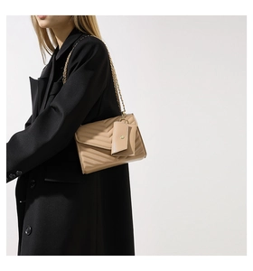 Dettaglio borsa a tracolla trapuntata beige con catena dorata e mini pochette coordinata