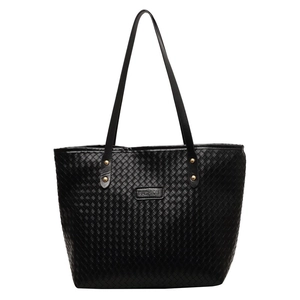 Minimalist black woven tote bag with slim shoulder straps and golden rivet accents