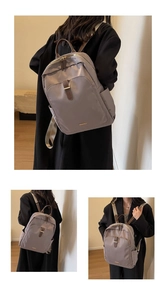 Detail of grey-purple waterproof nylon backpack with brown leather handles and metal zips