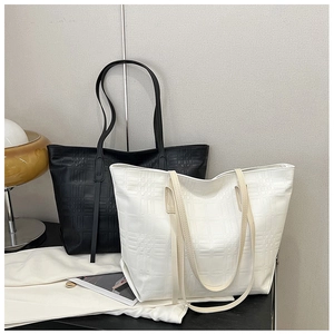 Detail of minimalist tote bags with textured embossed check pattern in black and beige colors