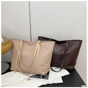 Detail view of large tote bags in beige and brown featuring textured checkered pattern
