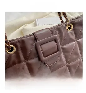 Close-up of brown quilted tote bag showing diamond stitch pattern and gold chain strap