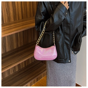 Pink glitter hobo bag with chunky gold chain strap styled on a leather jacket outfit