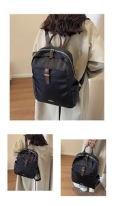 Detail view of black nylon laptop backpack with brown leather trim and metal zippers