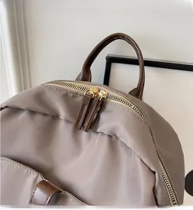 Detailed macro view of smooth golden dual-way zippers on gray nylon backpack