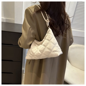 Detail of white quilted nylon shoulder bag with knotted strap and zipper closure