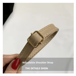 Détail de la bandoulière réglable en cuir beige avec boucle dorée et coutures fines