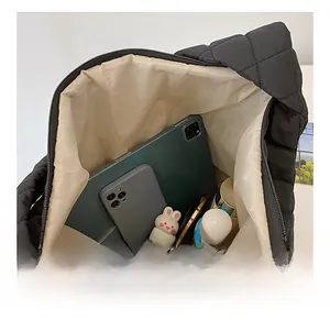 Vue détaillée de l'intérieur spacieux du sac cabas matelassé noir avec doublure beige clair