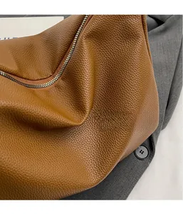 Gros plan d'un sac en cuir marron grainé avec une fermeture éclair dorée élégante