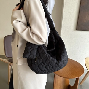 Detail of black puffer tote bag with heart quilting and matching heart coin purse