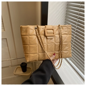 Detail of quilted tote bag in ginger PU leather with chain strap and large buckle
