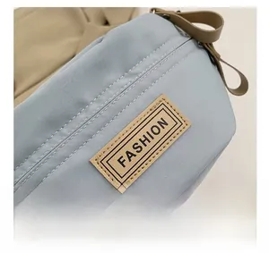 Dettaglio borsa in nylon azzurro con etichetta FASHION in pelle e rivetti