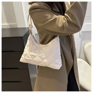 Close-up of white quilted puffer hobo bag featuring classic diamond stitched pattern
