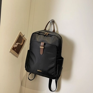 Minimalist black nylon laptop backpack with brown leather details for business and travel
