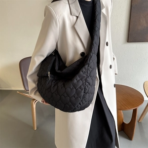 Close-up of heart quilted pattern on black lightweight nylon crossbody tote bag for women