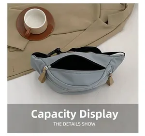 Dettaglio capacità della borsa a tracolla in nylon azzurro con cerniera e tirante in pelle
