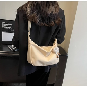 Détail du sac bandoulière beige en similicuir grainé avec large sangle tissée chic