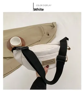 Dettaglio del marsupio in nylon bianco con etichetta FASHION e tracolla nera larga