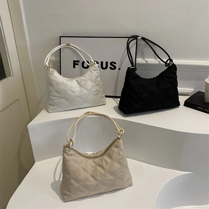 Quilted rhombic hobo bags in black, white, and beige on a minimalist display stand