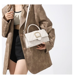 Détail d'un sac à main blanc matelassé avec fermoir doré et bandoulière réglable pratique