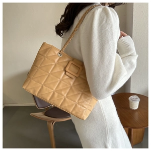 Detail shot of khaki quilted tote bag with matte PU leather and chain strap
