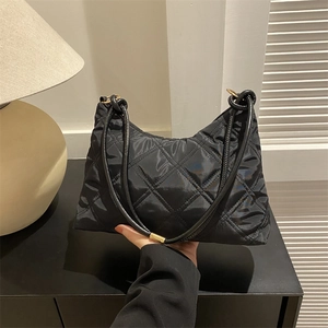 Classic black quilted nylon shoulder bag with elegant gold rings and top handle design