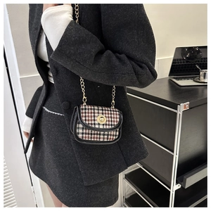 Close-up of vintage tweed plaid crossbody bag with gold chain strap and metal lock
