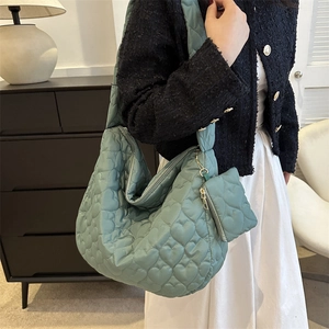 Detail of mint green heart quilted tote bag with matching heart-shaped zipper coin purse