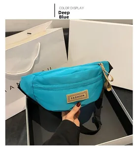 Dettaglio del marsupio in nylon blu scuro resistente all'acqua con etichetta in pelle
