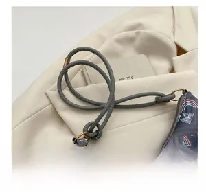 Close-up of quilted shoulder bag with rainbow print and golden hardware on blazer
