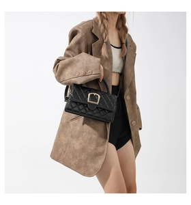 Sac à main matelassé noir chic avec fermoir doré porté par un mannequin de mode