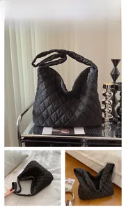 Détail d'un sac cabas noir matelassé avec un grand espace intérieur et une texture douce