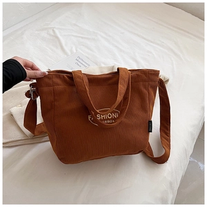 Detail of corduroy tote bag featuring adjustable shoulder strap and fashion embroidery